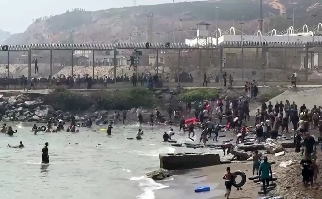 Migrants reaching the shore of Ceuta after swimming around the border fence between Morocco and Spain